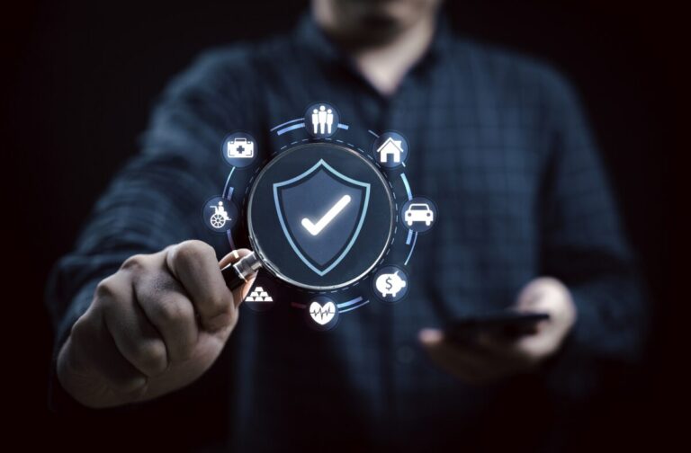 Businessman holds a magnifying glass with a shield icon for symb